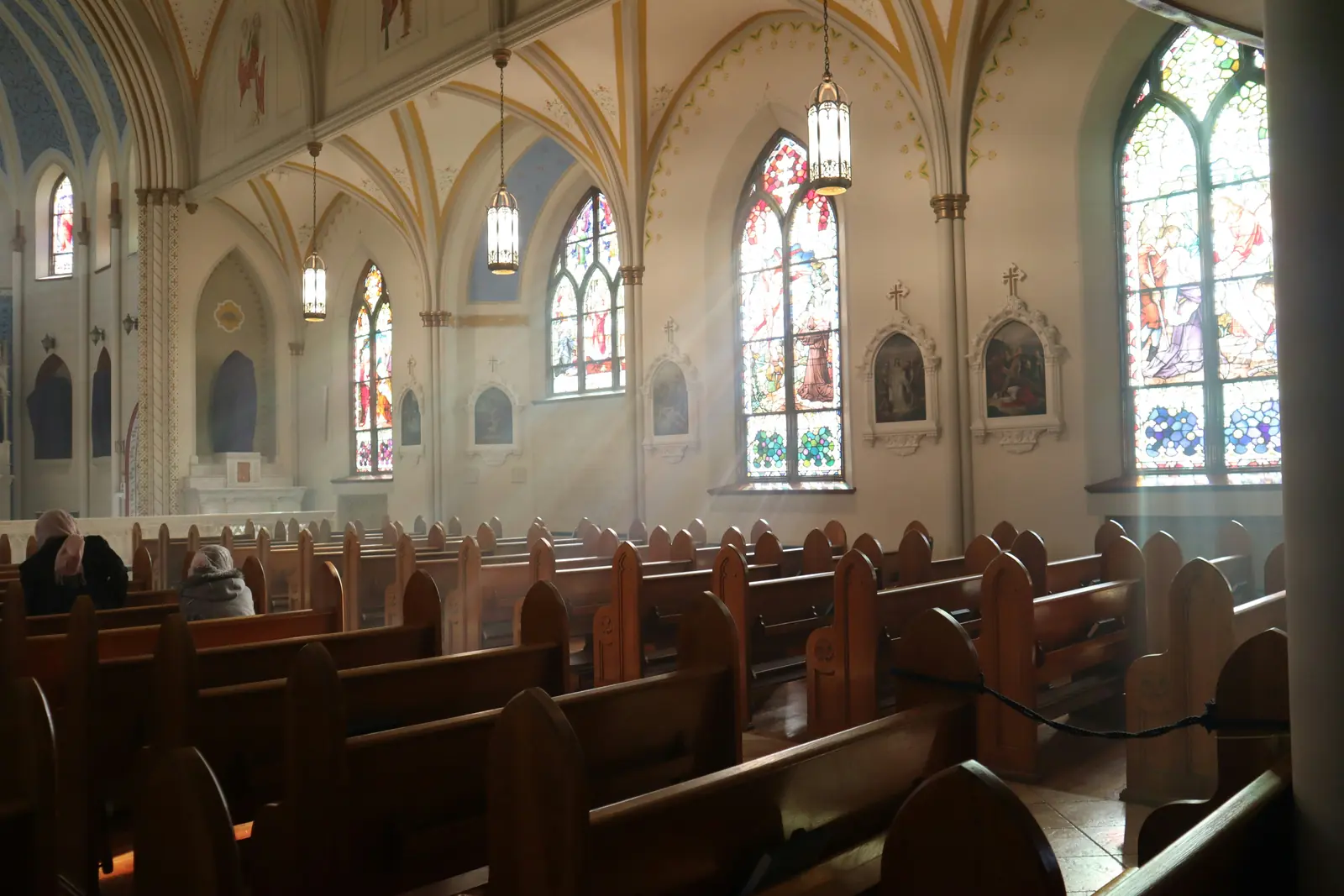 Leiter- und Trittprüfung in der Kirche: Hängeleuchten im gotischen Kirchenschiff.