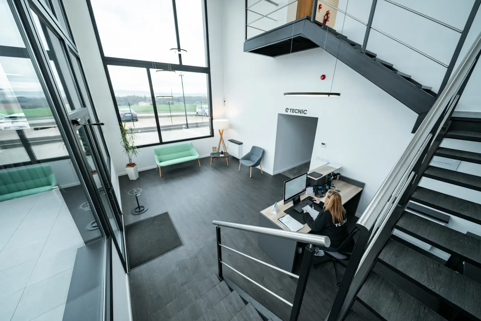Leiter- und Trittprüfung in der Versicherung: Stahltreppe und Galerie über dem Empfang.