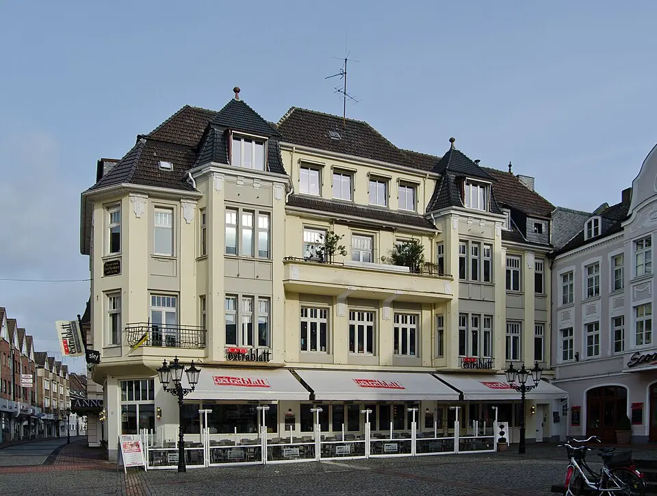 Betriebsmittelprüfung und Leiter- und Trittprüfung in Moers: Altstadthaus mit Markisen am Platz.