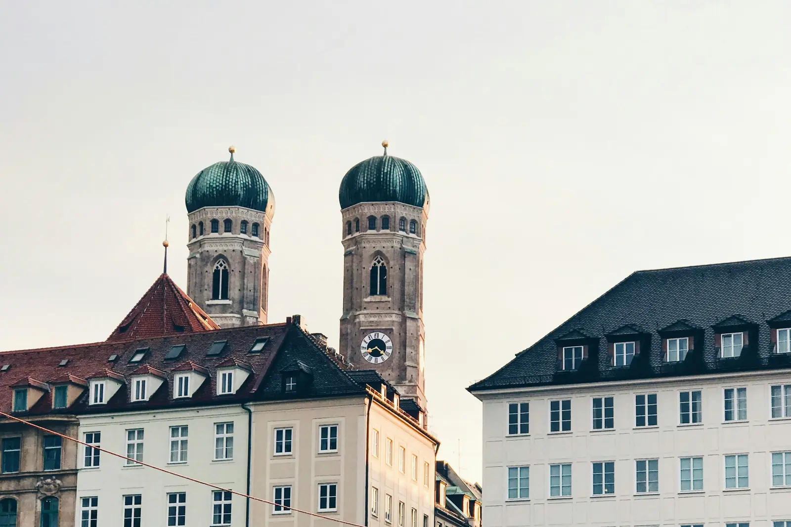 Betriebsmittelprüfung und Leiter- und Trittprüfung in München: Zwei Türme mit Zwiebelhauben über den Dächern.