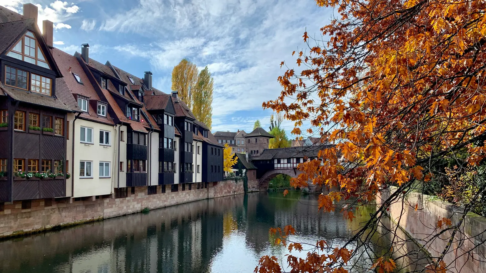 Betriebsmittelprüfung und Leiter- und Trittprüfung in Nürnberg: Fachwerkzeile am Fluss im Herbstlaub.