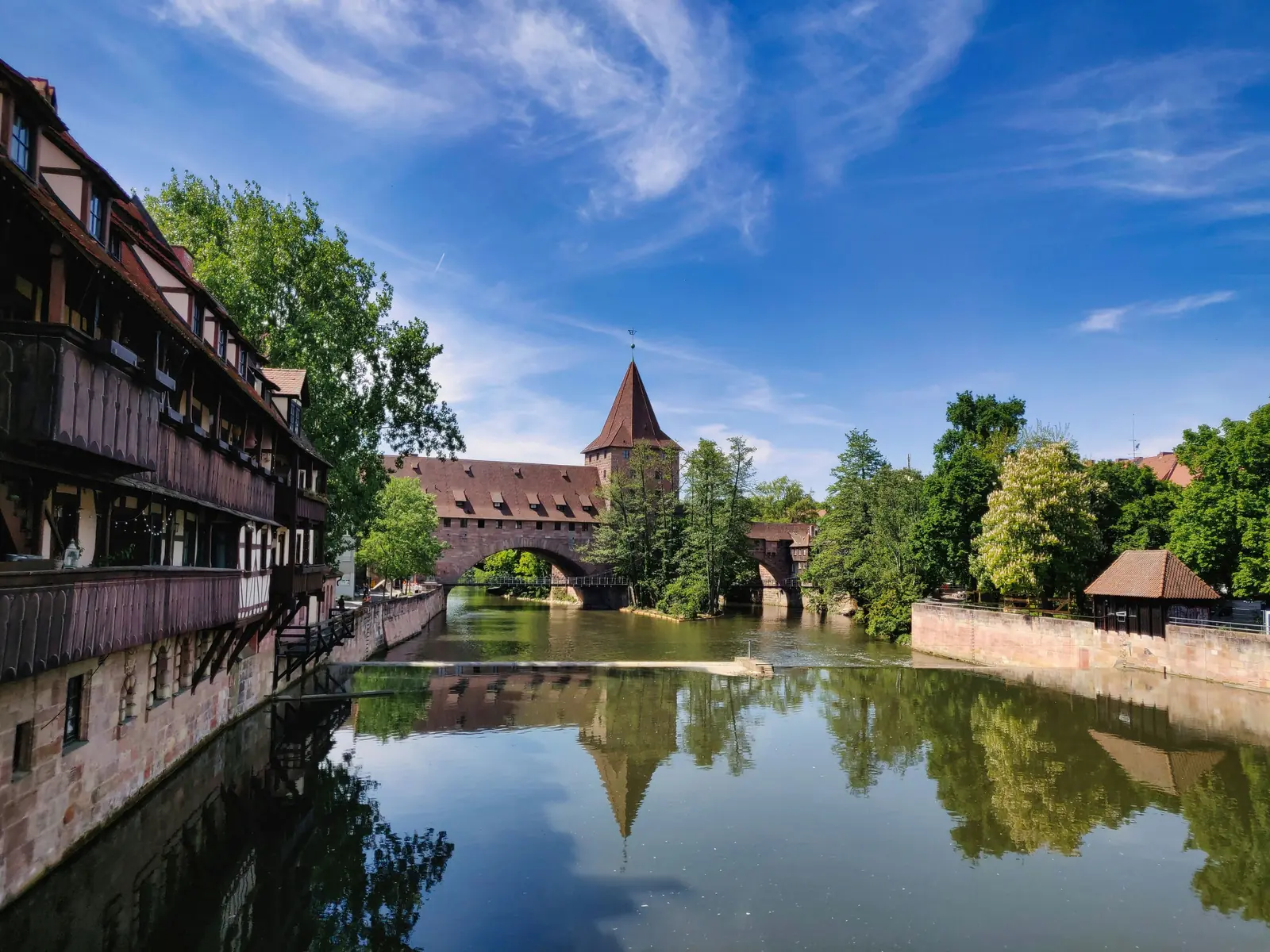 Betriebsmittelprüfung und Leiter- und Trittprüfung in Nürnberg: Gedeckte Brücke und Turm über dem Fluss.