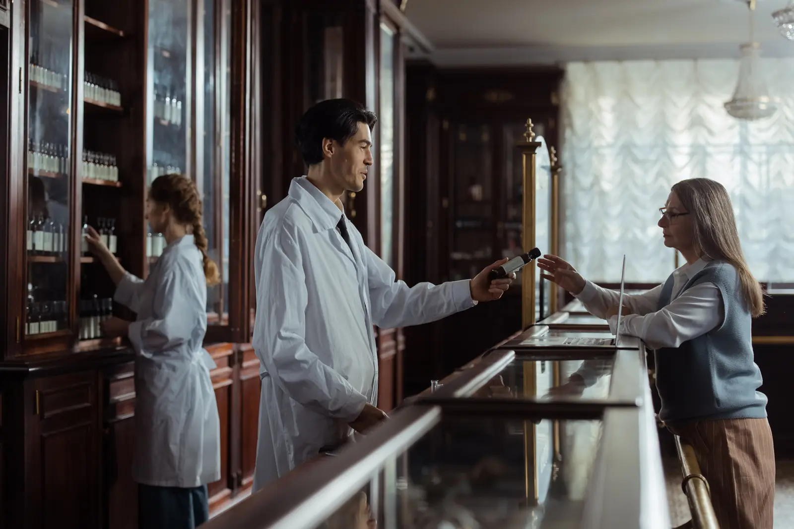 Betriebsmittelprüfung und Leiter- und Trittprüfung im Pharmaunternehmen: Übergabe eines Präparats am Tresen.