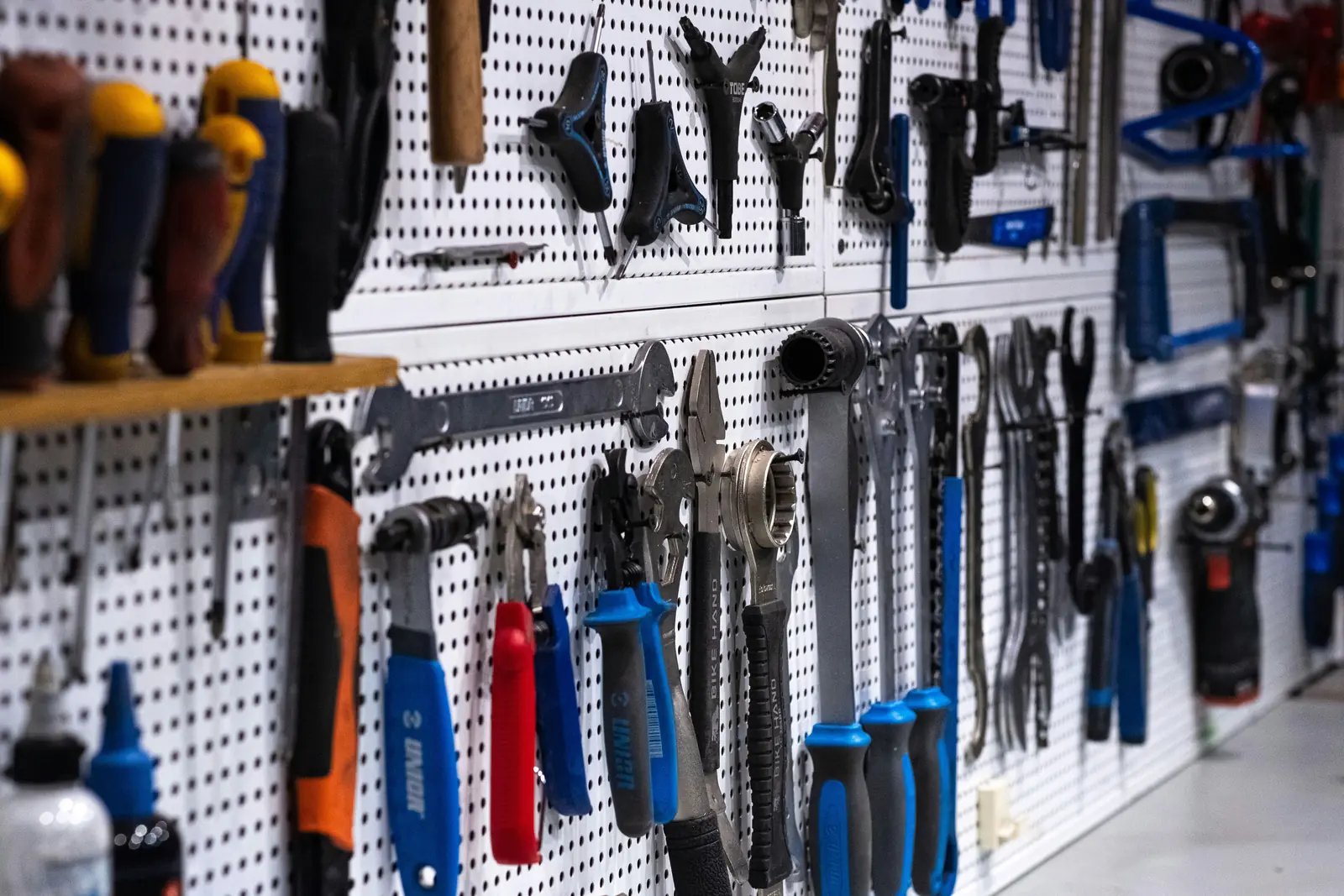 Betriebsmittelprüfung und Leiter- und Trittprüfung im Baumarkt: Werkzeugwand mit Handwerkzeug und Akkugeräten.