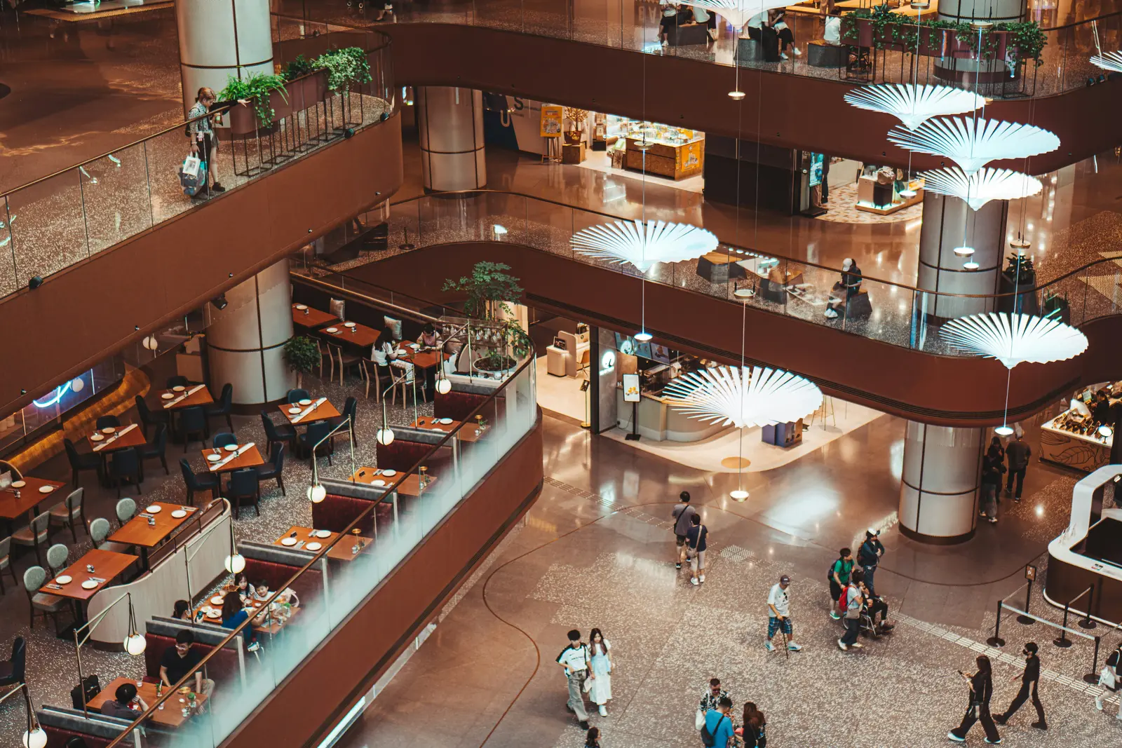 Betriebsmittelprüfung und Leiter- und Trittprüfung im Einkaufszentrum: Blick von oben auf Food-Court und Hängeleuchten.
