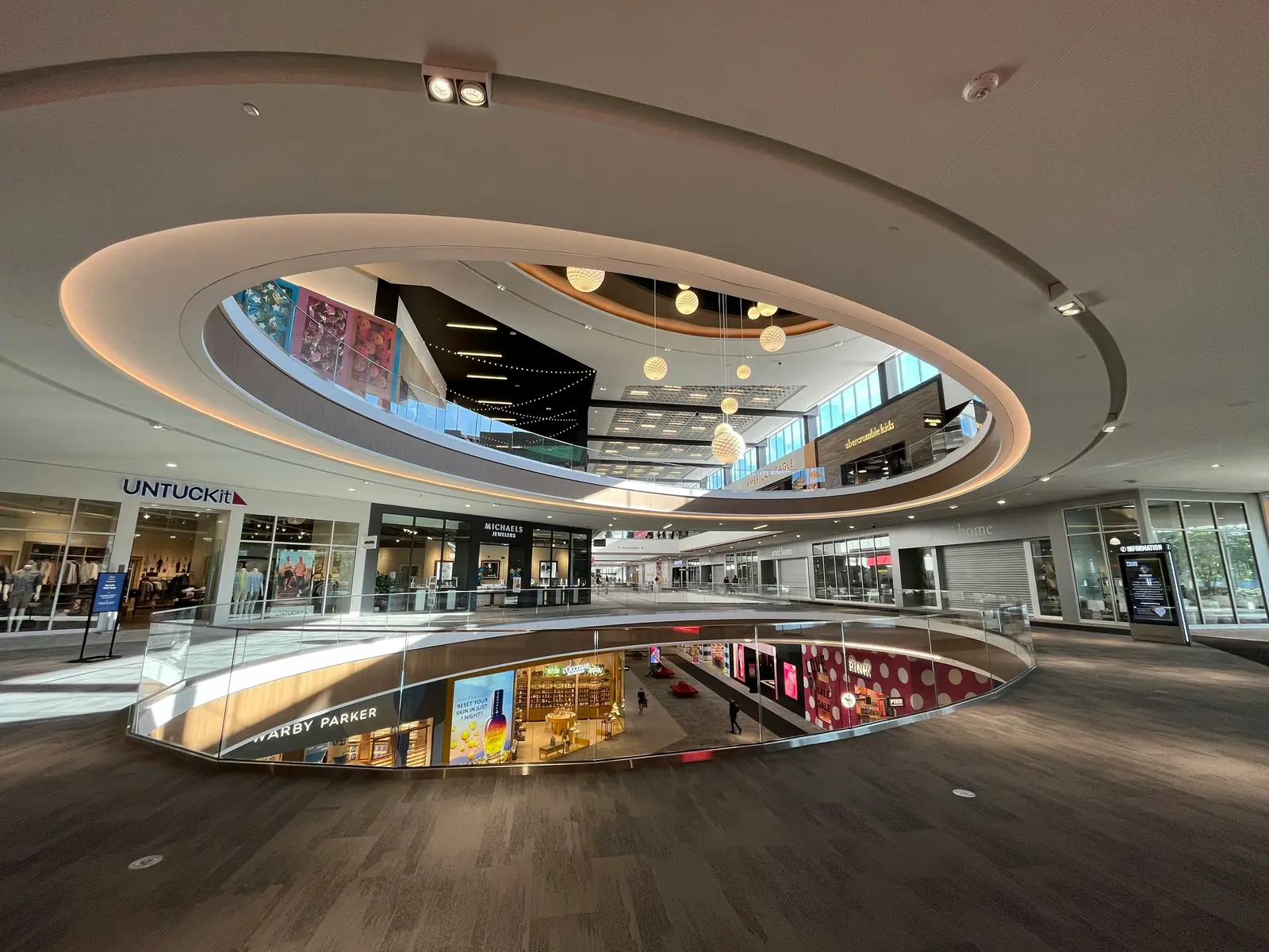 Betriebsmittelprüfung und Leiter- und Trittprüfung im Einkaufszentrum: Galerie mit Deckenleuchten und Ladenzeile.