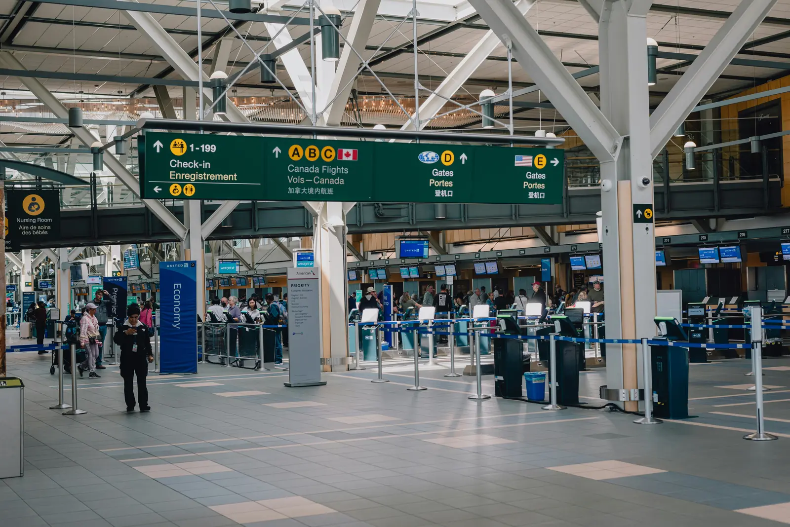 Betriebsmittelprüfung und Leiter- und Trittprüfung am Flughafen: Check-in-Bereich mit Hinweisschildern.