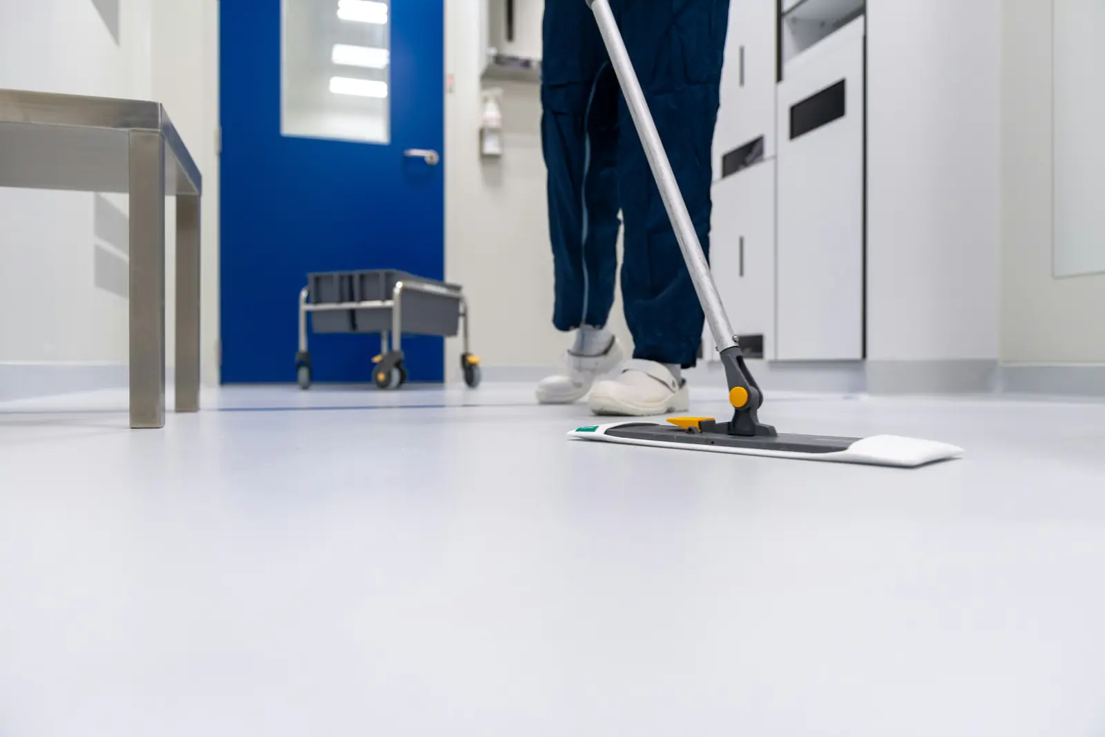 Betriebsmittelprüfung und Leiter- und Trittprüfung in der Gebäudereinigung: Bodenreinigung in einem Laborflur.