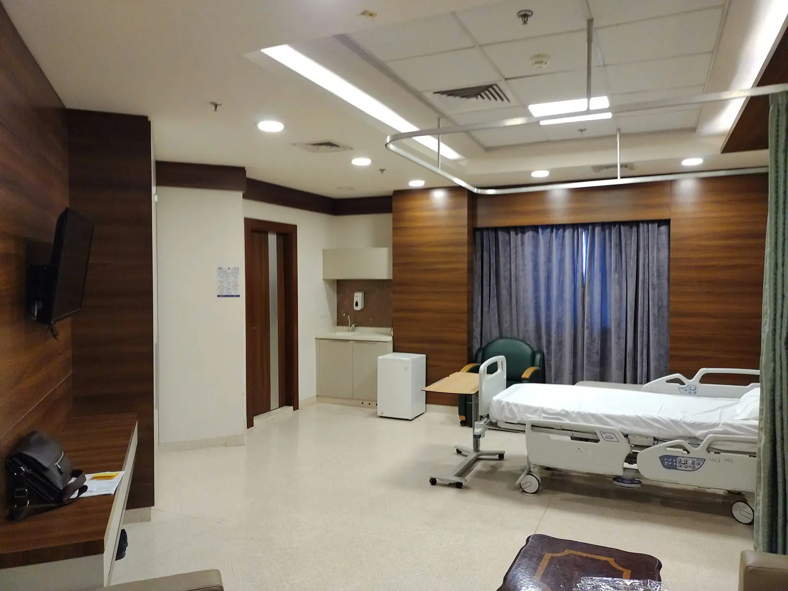 Betriebsmittelprüfung und Leiter- und Trittprüfung im Krankenhaus: Patientenzimmer mit Deckenleuchten und Fernseher.
