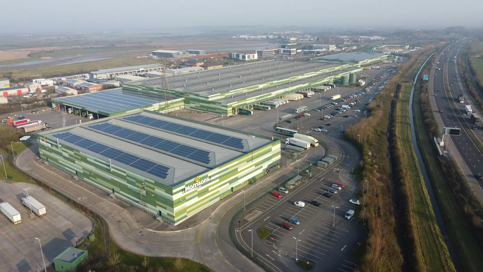 Betriebsmittelprüfung und Leiter- und Trittprüfung im Lager: Luftbild einer Logistikhalle mit Photovoltaik.