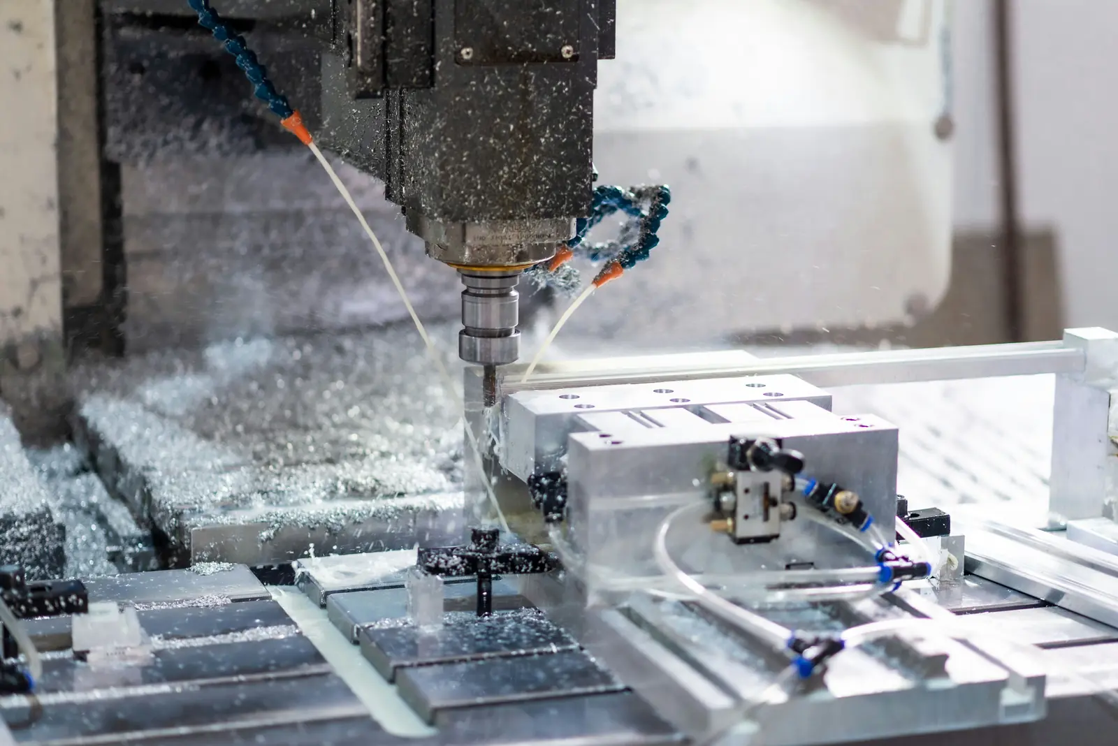 Betriebsmittelprüfung und Leiter- und Trittprüfung im Maschinenbau: CNC-Fräse mit Kühlmittelstrahl.
