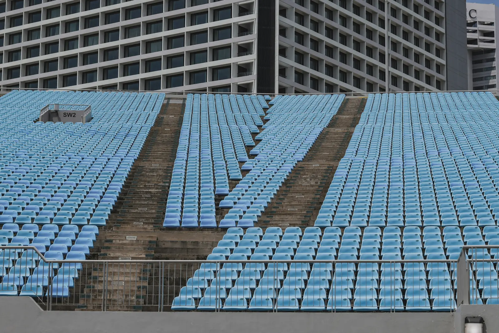 Betriebsmittelprüfung und Leiter- und Trittprüfung im Stadion: Leere Tribüne mit blauen Sitzschalen.