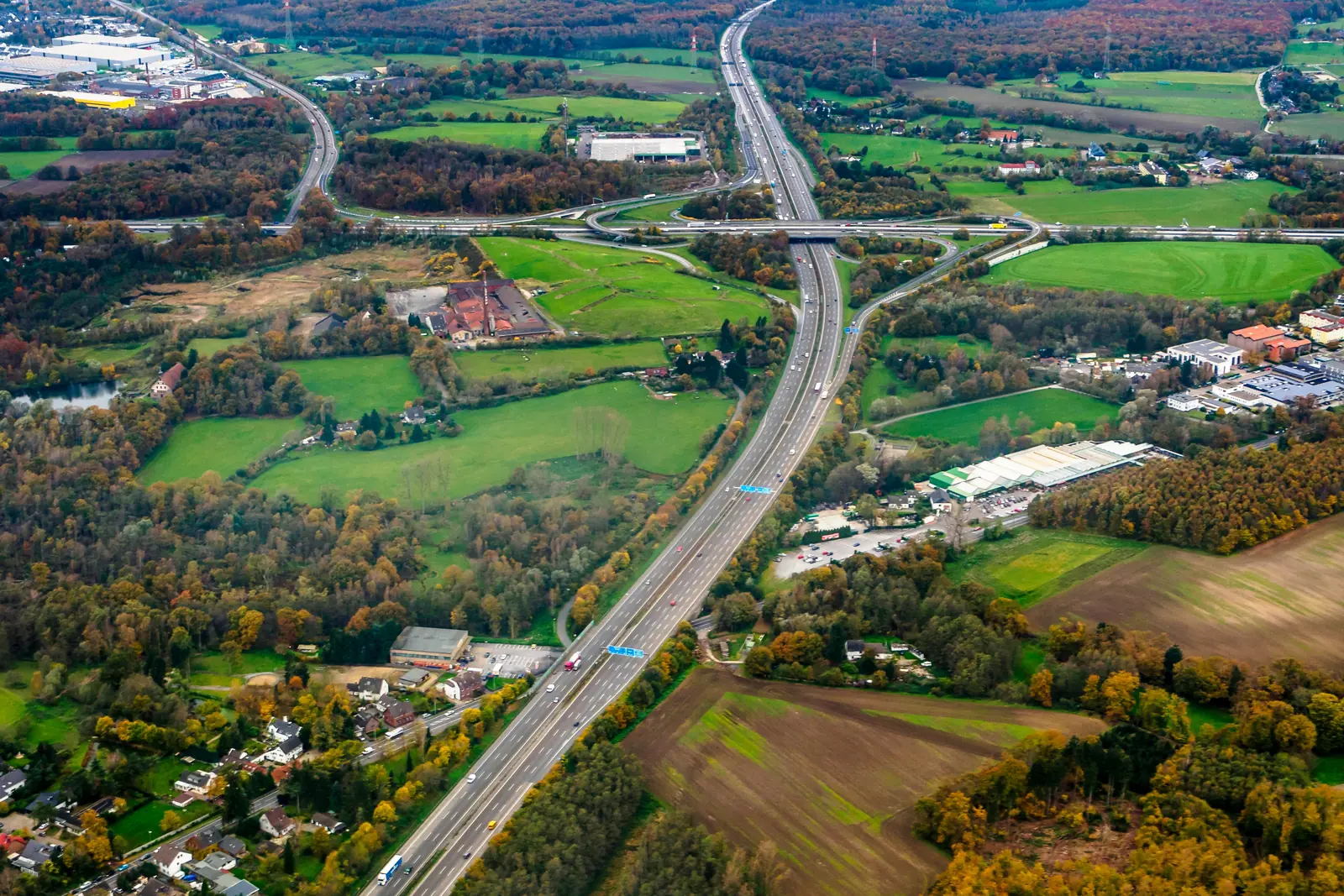 Betriebsmittelprüfung und Leiter- und Trittprüfung in Ratingen: Luftbild von Autobahn und Feldern im Herbst.