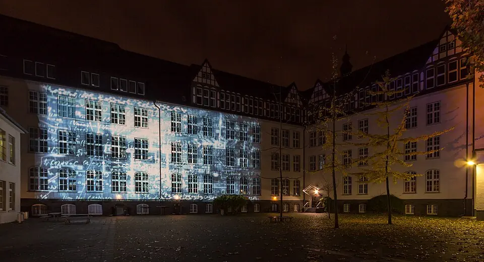 Betriebsmittelprüfung und Leiter- und Trittprüfung in Recklinghausen: Lichtprojektion auf einer Fassade bei Nacht.