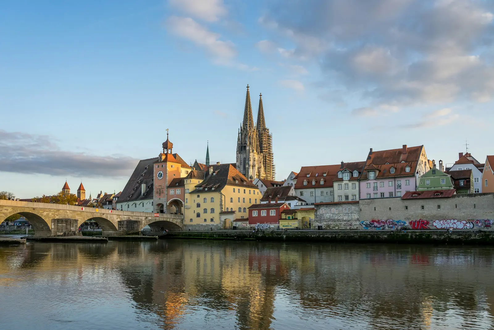 Betriebsmittelprüfung und Leiter- und Trittprüfung in Regensburg: Steinerne Brücke und Dom am Flussufer.