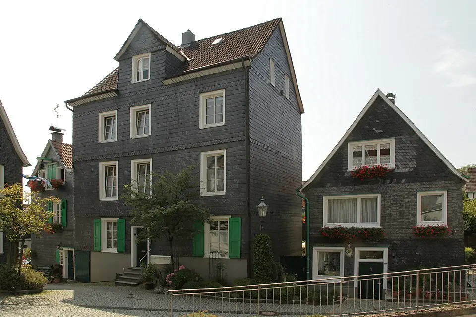 Betriebsmittelprüfung und Leiter- und Trittprüfung in Remscheid: Schieferverkleidete Häuser mit grünen Fensterläden.
