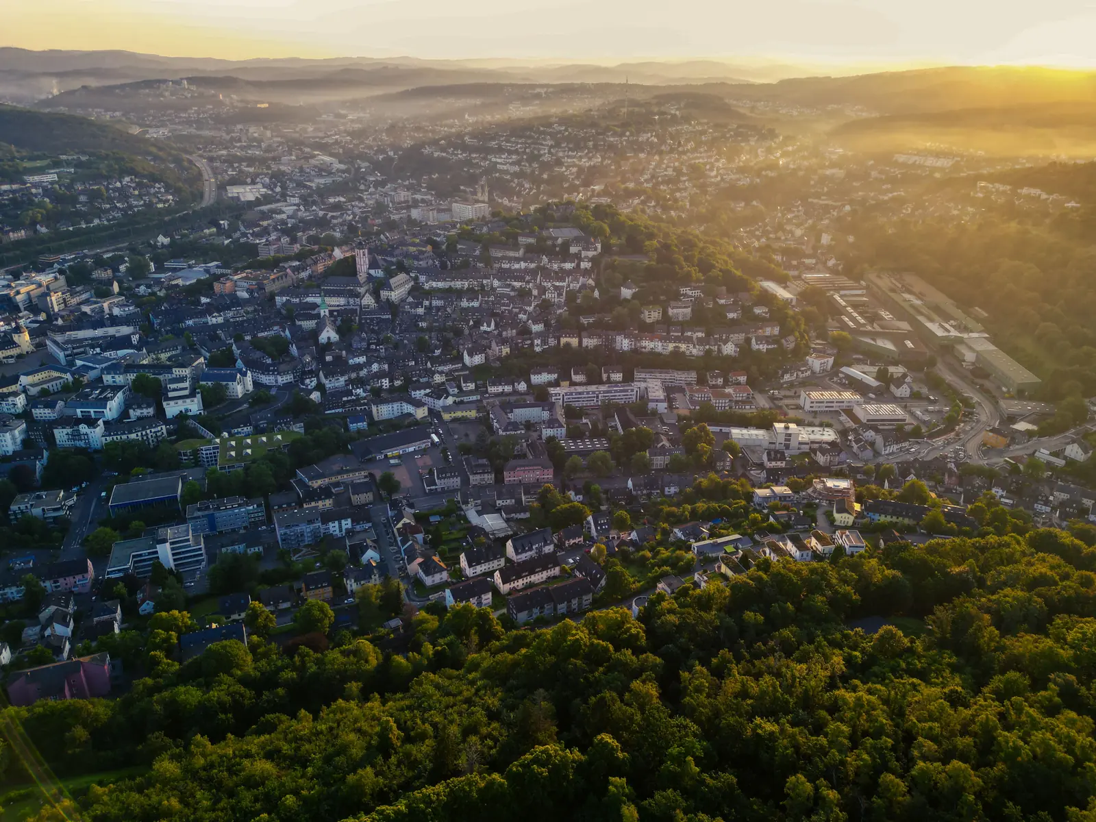 Betriebsmittelprüfung und Leiter- und Trittprüfung in Siegen: Luftaufnahme der Stadt im Morgenlicht.