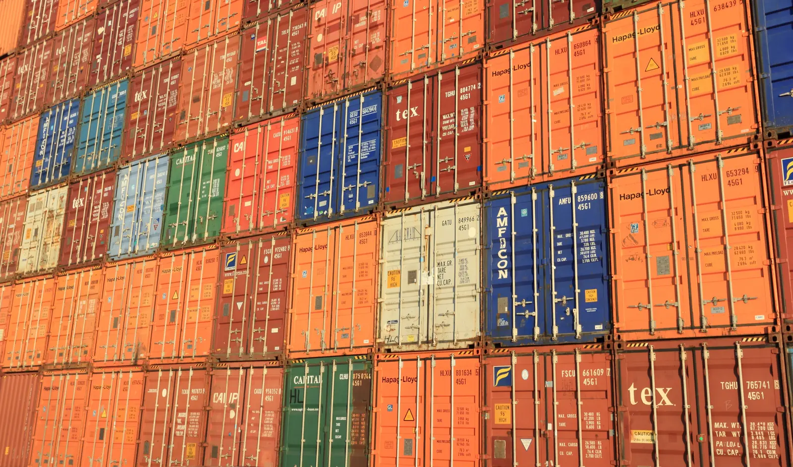 Betriebsmittelprüfung und Leiter- und Trittprüfung in der Spedition: Containerwand aus gestapelten Boxen.