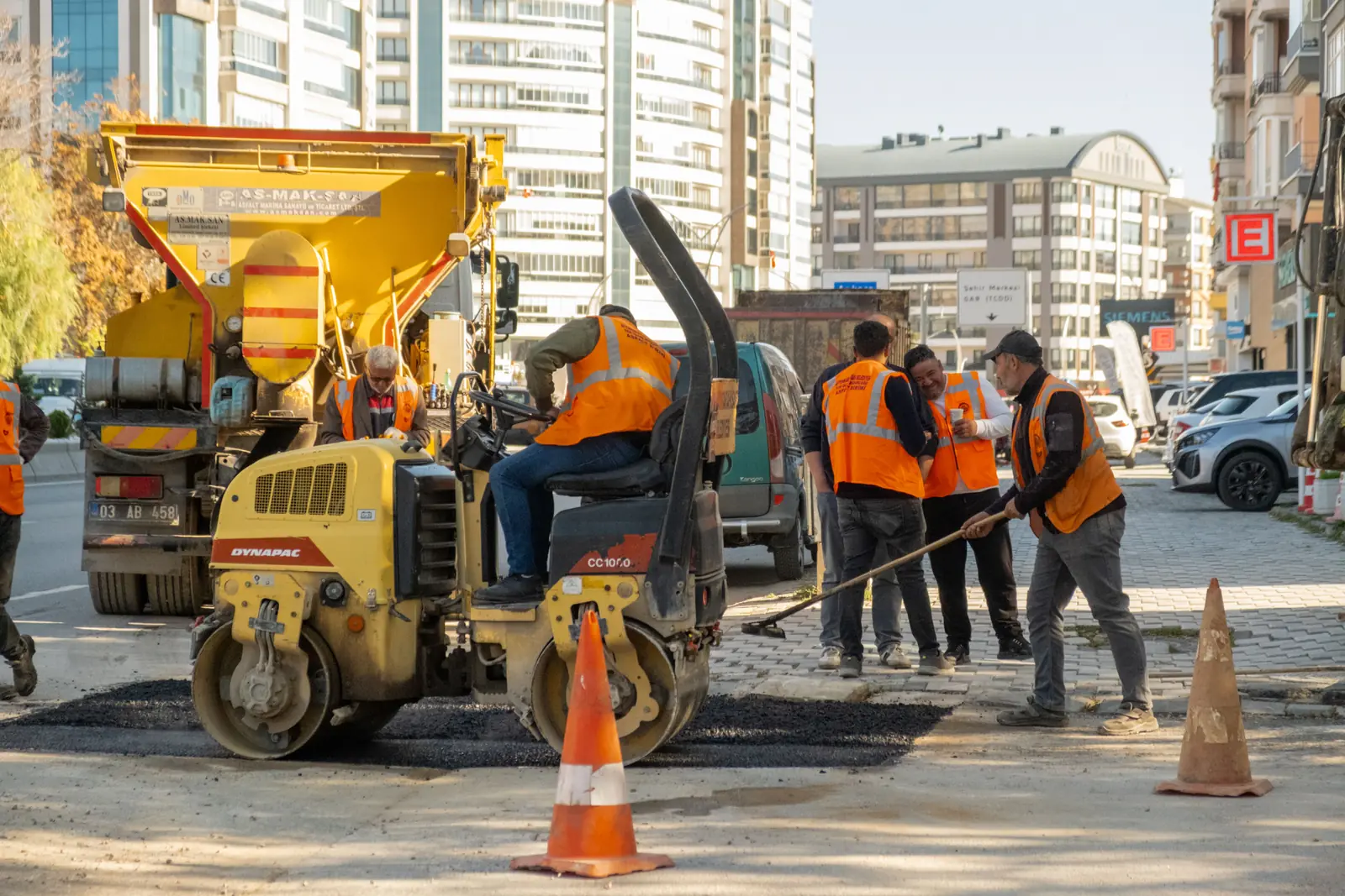 Betriebsmittelprüfung und Leiter- und Trittprüfung bei den Stadtwerken: Kolonne mit Walze bei Asphaltarbeiten.