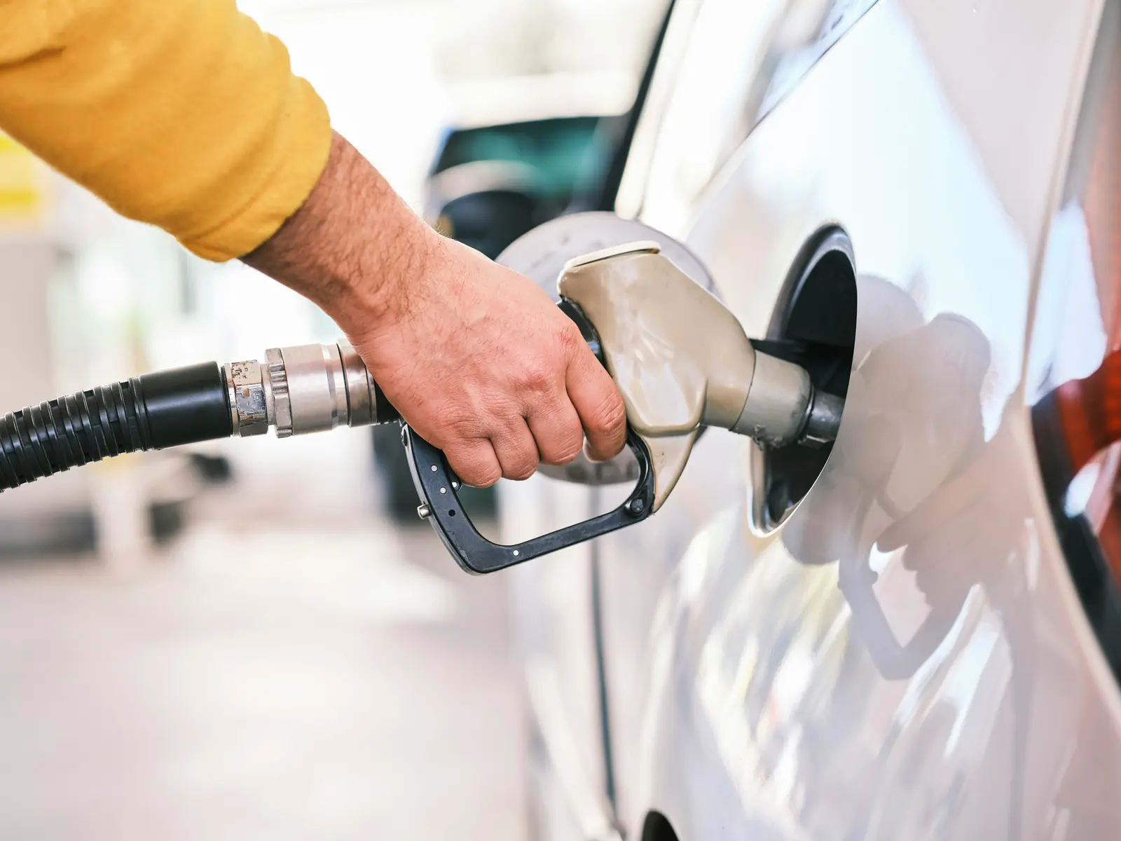 Betriebsmittelprüfung und Leiter- und Trittprüfung an der Tankstelle: Zapfpistole im Tankstutzen eines Autos.