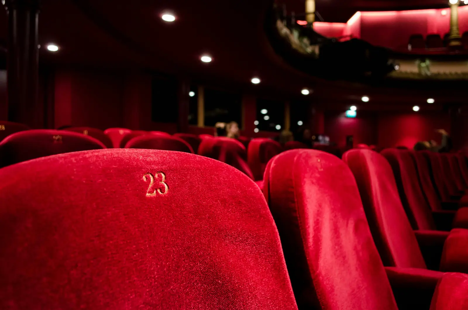 Betriebsmittelprüfung und Leiter- und Trittprüfung im Theater: Nummerierte Samtsessel im Zuschauerraum.