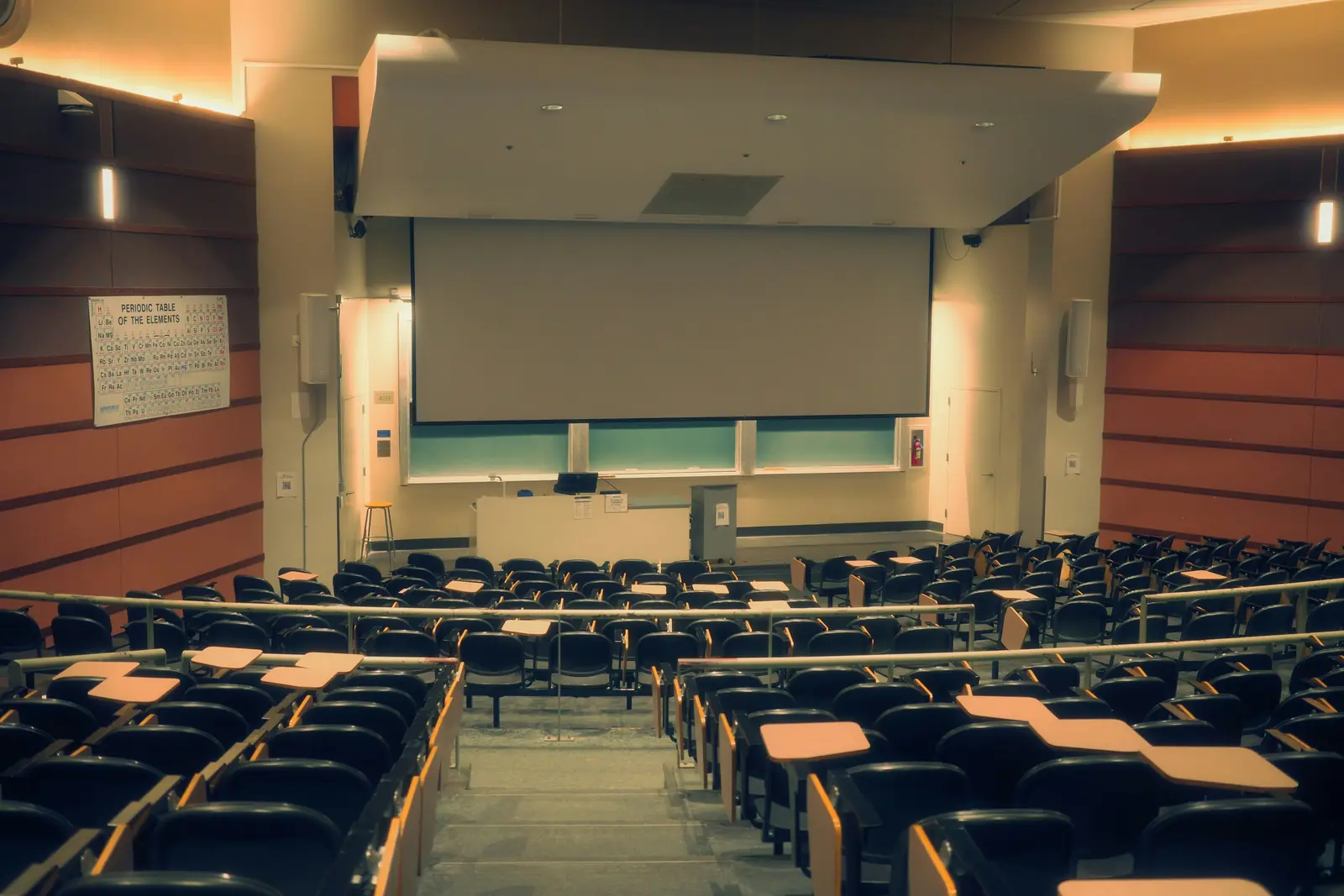 Betriebsmittelprüfung und Leiter- und Trittprüfung an der Universität: Leerer Hörsaal mit Projektionsfläche.