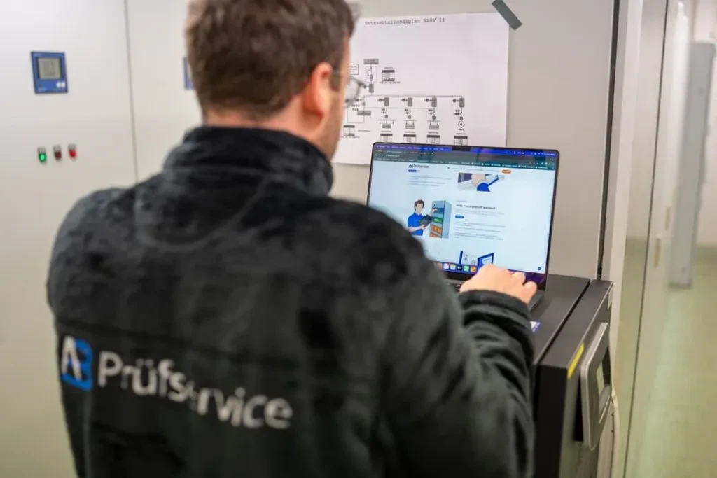 Ein Mann in einer schwarzen Jacke benutzt einen Laptop.